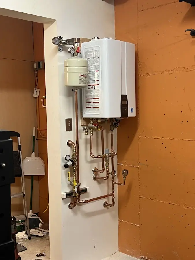 Plumbing technician inspecting water heater connections in Morehead